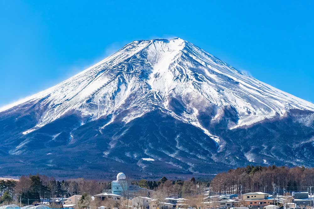 雪化粧した富士山と富士吉田の街並み